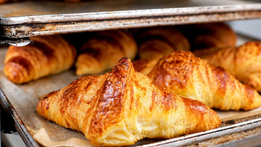 Croissant dorati sulle teglie del laboratorio di Forneria Santa Rita