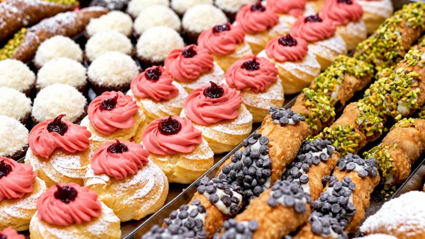Assortimento di pasticceria mignon con cannoli e dolci decorati con crema